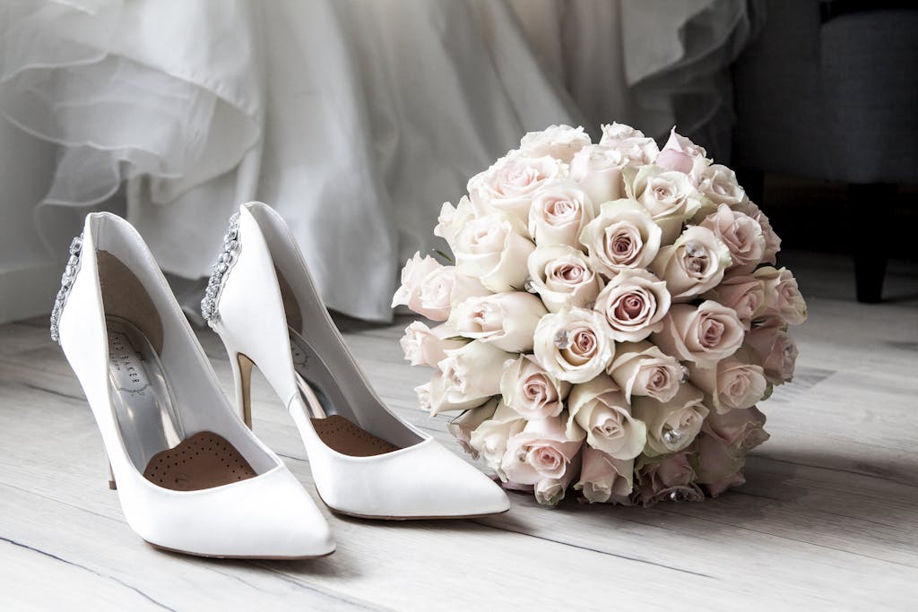 Mise en scène romantique escarpins et roses pâles : un souvenir poétique signé par le Studio Vauban lors de la matinée de préparation. Votre photographe de mariage sublime chaque élément de votre tenue.